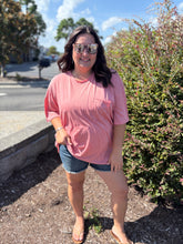 Load image into Gallery viewer, Woman wearing a pink shirt and denim shorts standing outdoors on a sunny day.