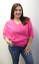 Load image into Gallery viewer, Woman wearing a pink sweater and blue jeans against a white wall