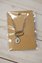 Load image into Gallery viewer, Silver chain necklace on a clear plastic card with a brown backing, placed on a wooden surface.