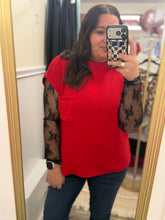 Load image into Gallery viewer, Woman wearing a red mock neck short sleeve sweater over a floral lace shirt, standing in front of a mirror.