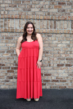 Load image into Gallery viewer, Woman in a red dress standing against brick wall