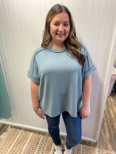 Load image into Gallery viewer, Woman wearing a light blue ribbed sweater and jeans indoors.