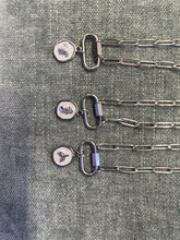 Load image into Gallery viewer, Three silver necklaces with pendant charms on a textured gray background