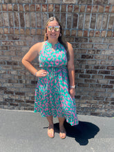 Load image into Gallery viewer, Woman wearing a pink and green dress standing against a brick wall.