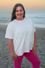Load image into Gallery viewer, Woman standing on a beach wearing a white top and pink pants.