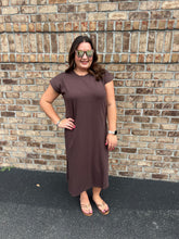 Load image into Gallery viewer, Woman wearing a brown dress standing against a brick wall.