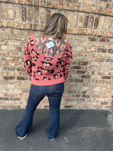 Load image into Gallery viewer, Person wearing a pink sweater with black patterns standing against a brick wall.
