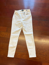 Load image into Gallery viewer, White pants on a wooden floor
